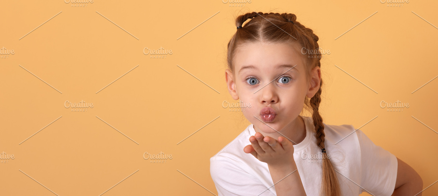 Adorable young girl in white t-shirt blowing a kiss with playful, a Person Photo by Ales Munt