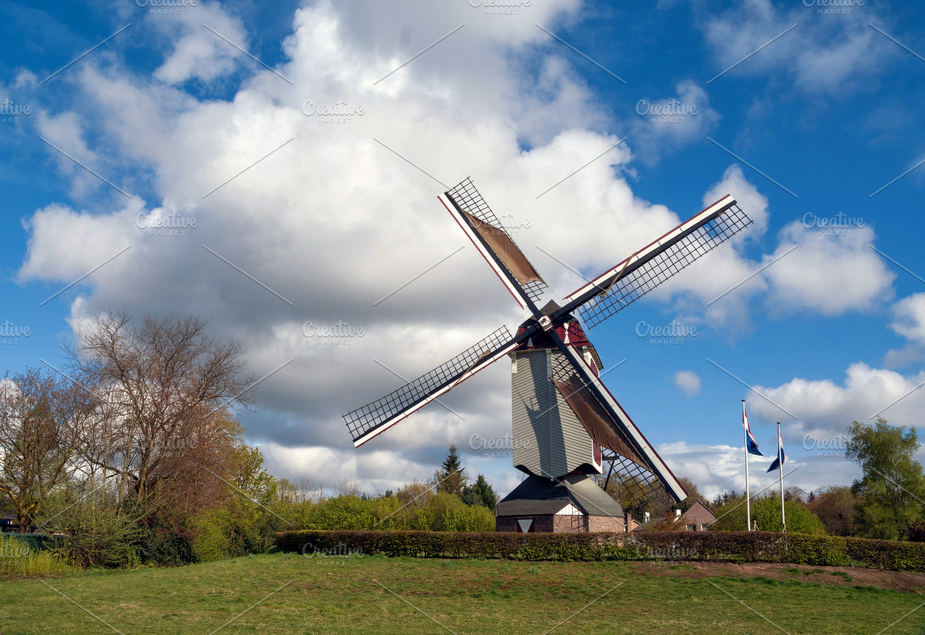 White clouds and blue sky above the Oostenwind windmill, an Architecture Photo by John Stuij Photography