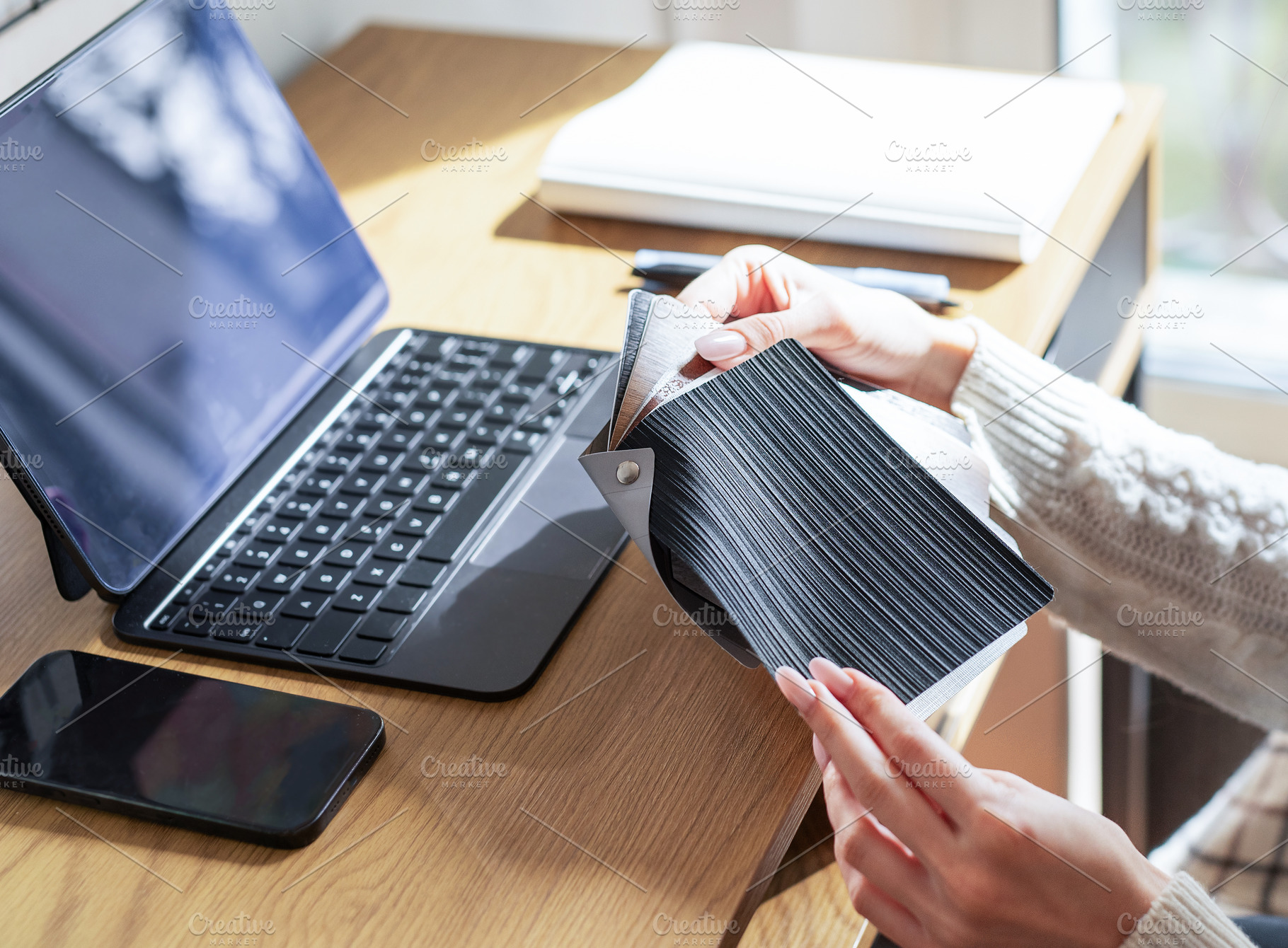 Designer choosing material swatches at home office workspace, a Business Photo by Olena Rudo