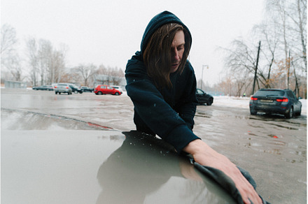 Person cleaning a car hood in a
