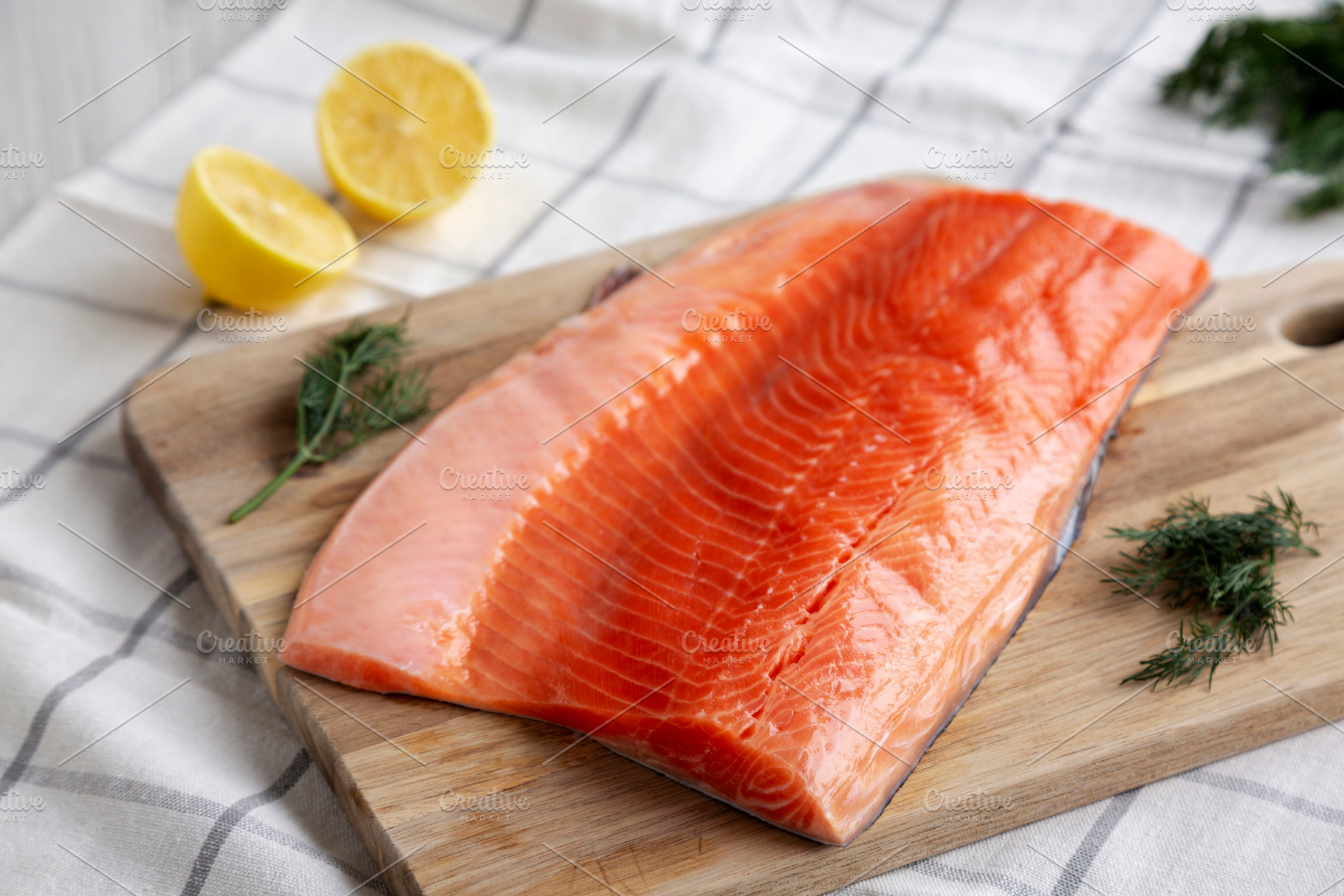 Organic Raw Salmon Fillet on a wooden board, side view., a Food & Drink Photo by LiudmylaChuhunova