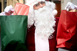 Happy Santa Claus carrying Christmas shopping bags, a Person Photo by etorres69