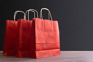 Three red paper shopping bag on wooden and isolated background, an Industrial Photo by Davizro's Market