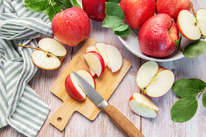Fresh aed apples slicing on wooden cutting board, a Food & Drink Photo by Olena Rudo