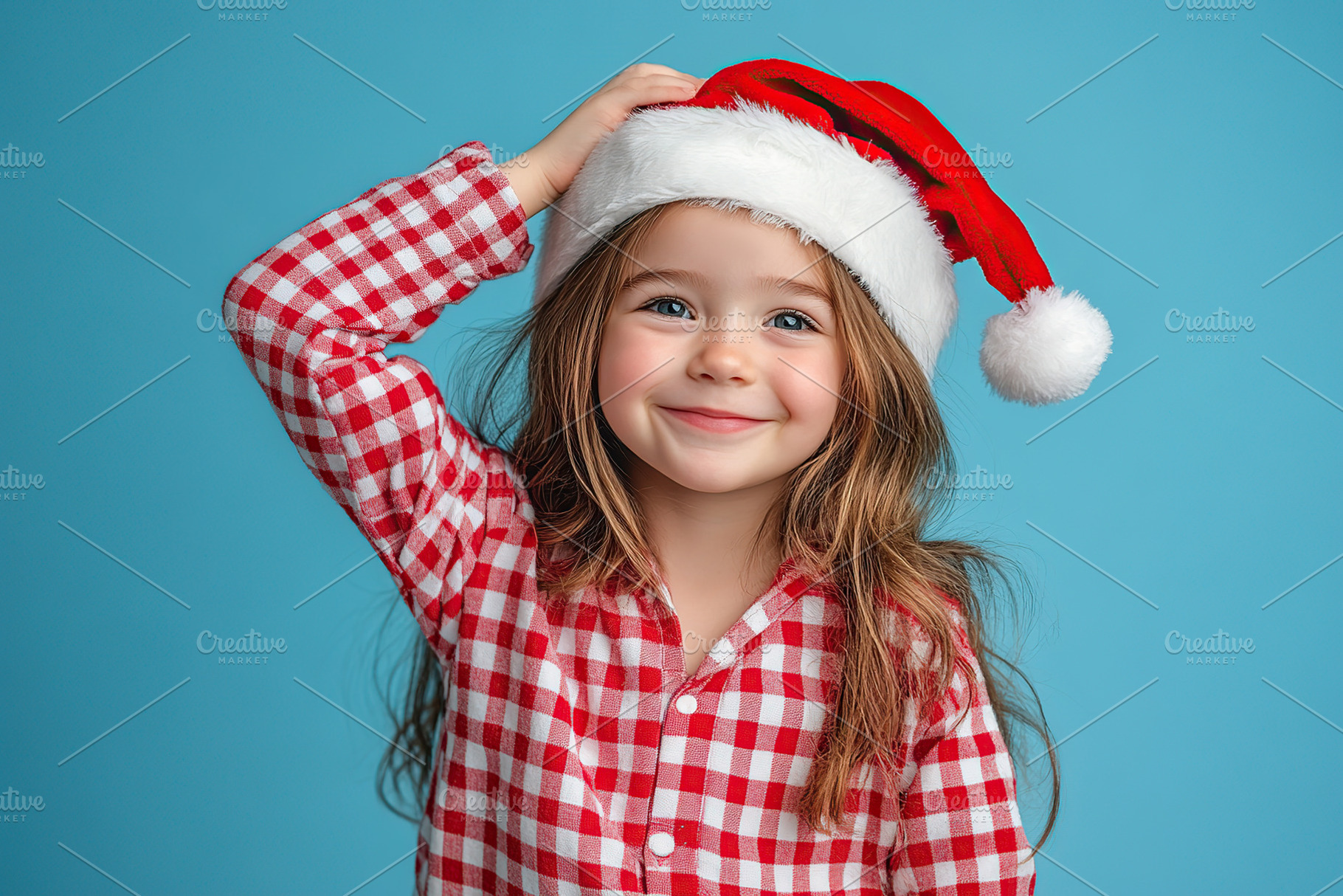 Smiling child girl in checkered pajamas and red santa hat, a Holiday Photo by AlyaAnd