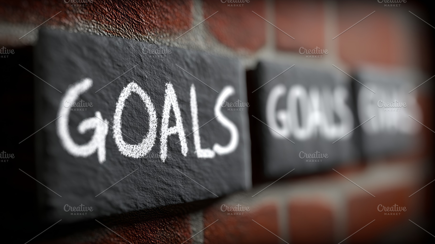 Goals written in chalk on slate tiles against a brick wall conveying ambition,, a Photo by AS photostudio