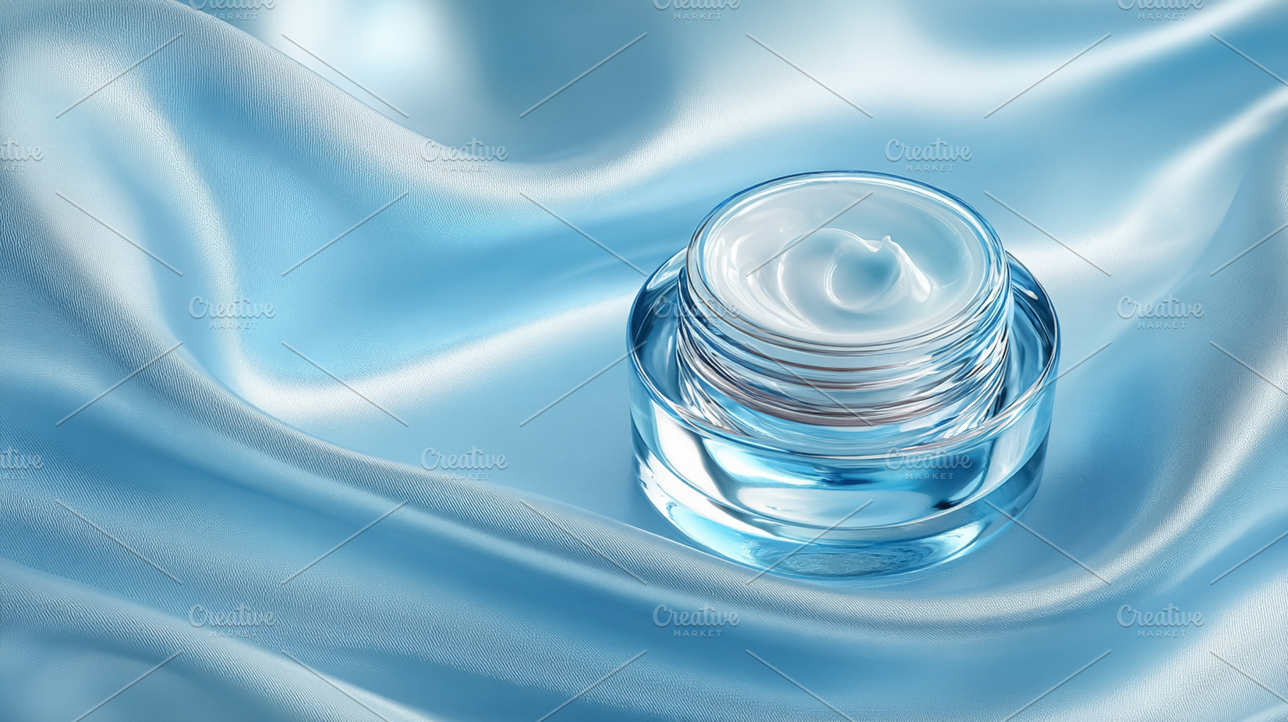 Hydrating face cream in a glass jar on blue silk fabric, represe, a Photo by Studio ANNA