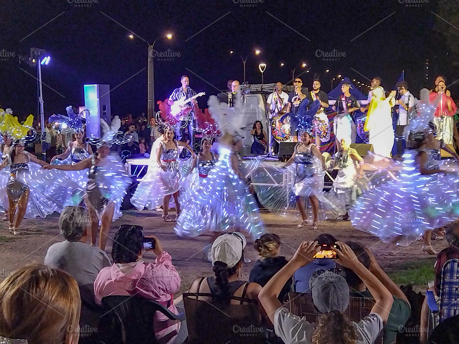 Audience watching outdoor performance at night, an Architecture Photo by DanFLCreativo