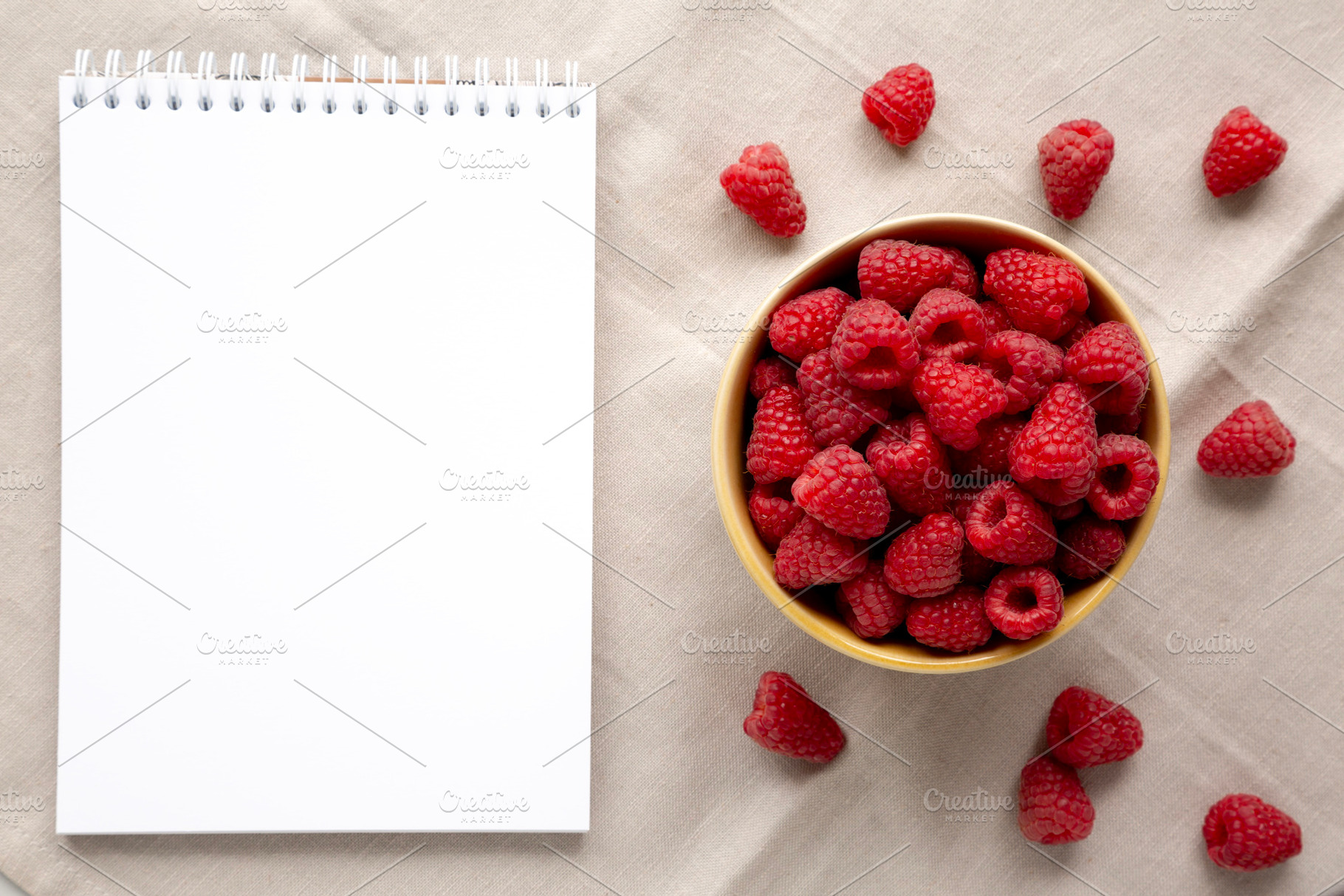 Organic Raw Red Raspberries in a Bowl, blank notepad, top view., a Food & Drink Photo by LiudmylaChuhunova
