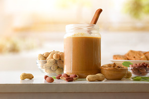Jar and bowl filled with peanut butter and background cooking, a Food & Drink Photo by Davizro's Market