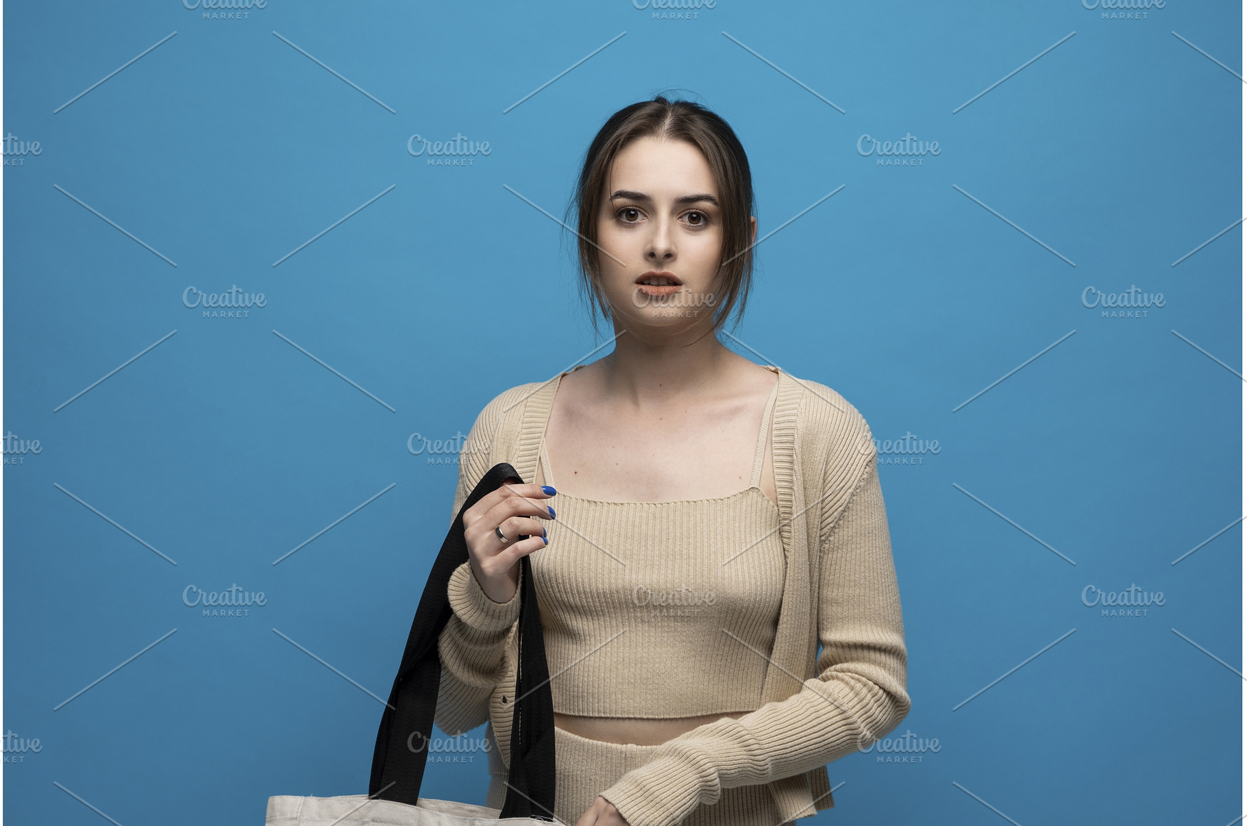 Young woman in beige outfit holding, a Beauty & Fashion Photo by volodymyrshtun13795