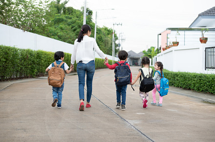 Group of preschool student and teacher holding hands and walking, a Person Photo by Ministocker