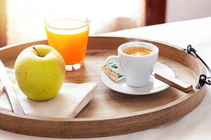Delicious breakfast with coffee, juice and apple on wooden tray, a Food & Drink Photo by Antonio Gravante Market