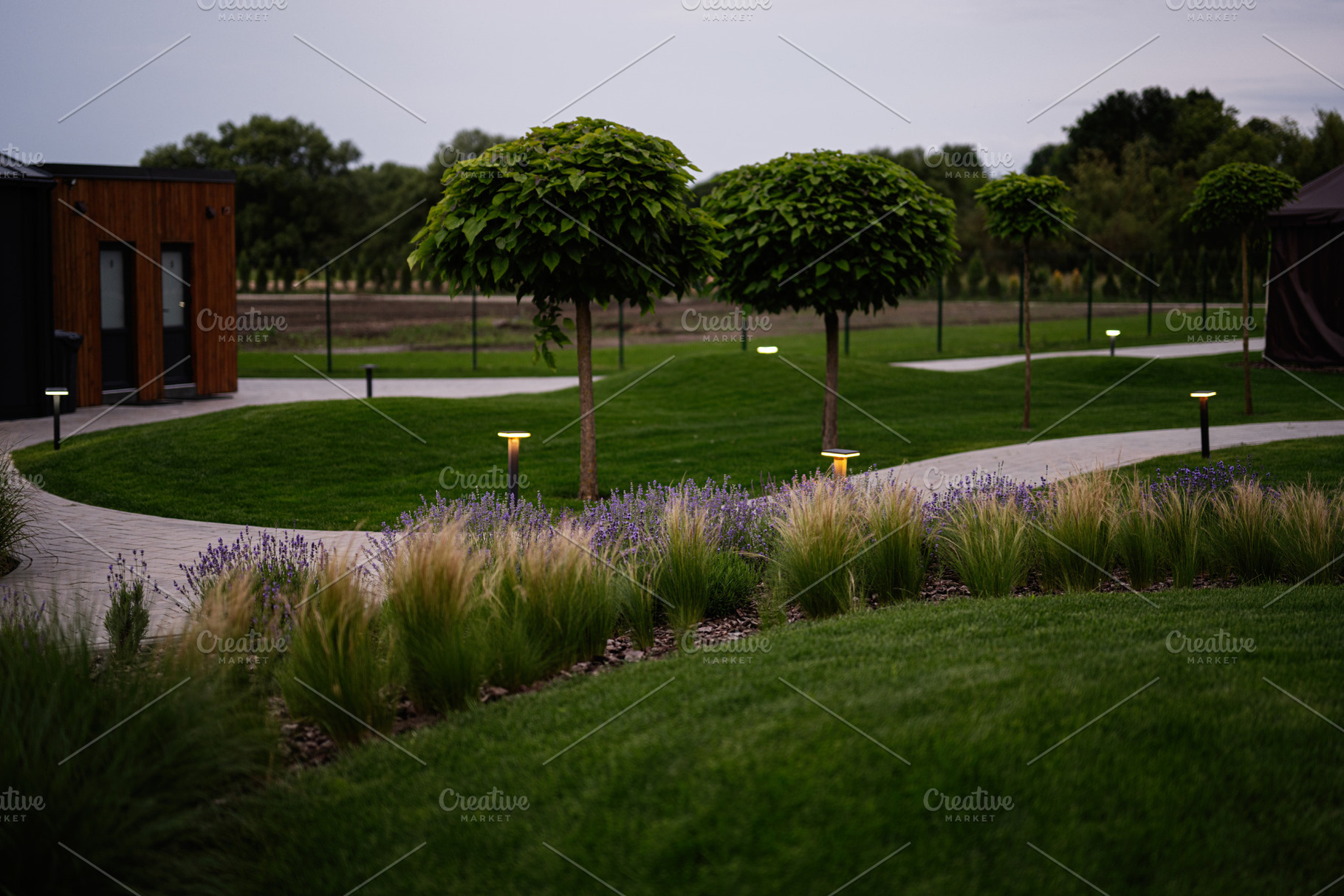 Beautifully landscaped garden with trimmed trees and walking pathways, a Photo by AS photostudio