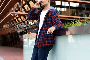 Caucasian man talking on smartphone near modern building, a Person Photo by RF Images