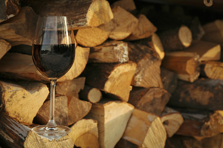 Glass of wine outdoor on folded firewood, a Nature Photo by AtlasStudio PRO