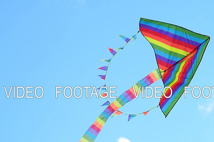 Rainbow kite flying against blue sky