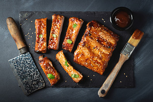 Barbecue pork spare ribs with hot honey chili marinade on black background, a Food & Drink Photo by Budarinphoto