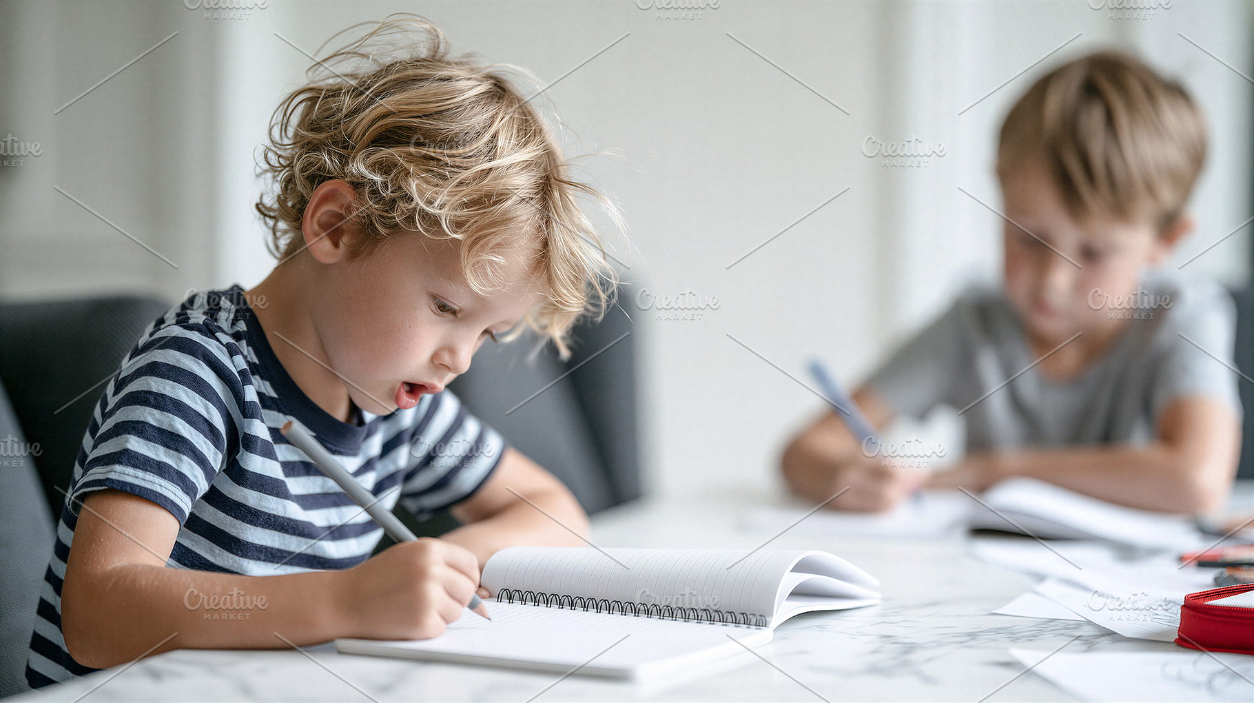 Two young boys writing in notebooks, a School & Education Photo by 7DesignLab