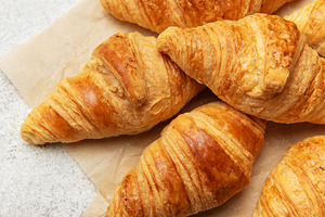 Freshly baked croissants with wheat on baking paper, a Food & Drink Photo by Olena Rudo