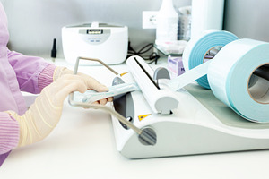 Nurse sealing sterile medical instruments using vacuum packing machine, a Health & Medical Photo by Antonio Gravante Market