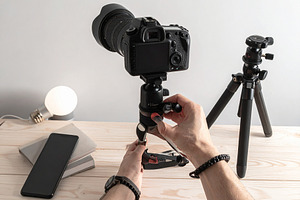 Wooden desk with hand handling with filming equipement, a Technology Photo by DanFLCreativo