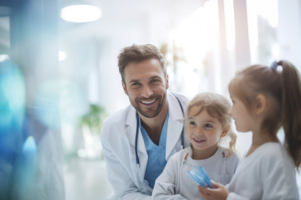 Happy paediatrician playing with kids, volunteer work