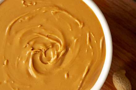 Organic Peanut Butter in a Bowl, top view. Flat lay, overhead.