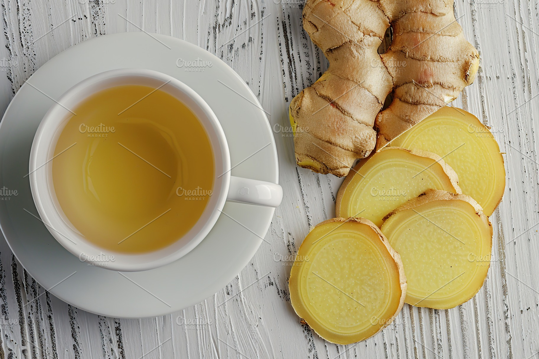 Cup of ginger tea with sliced ginger root on wooden table, a Food & Drink Photo by AlyaAnd
