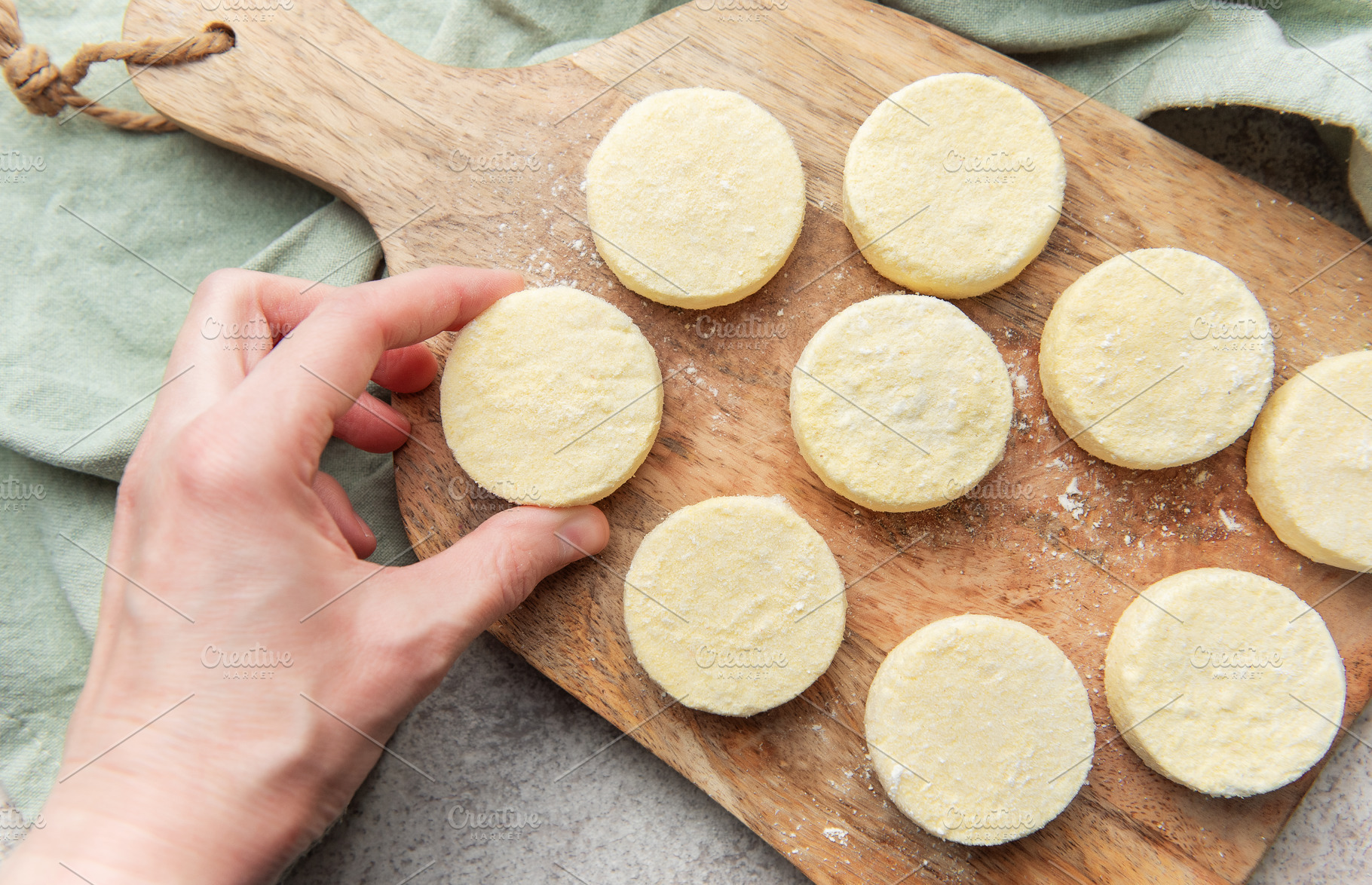 Hand preparing syrniki cottage cheese pancakes on wood, a Food & Drink Photo by Olena Rudo