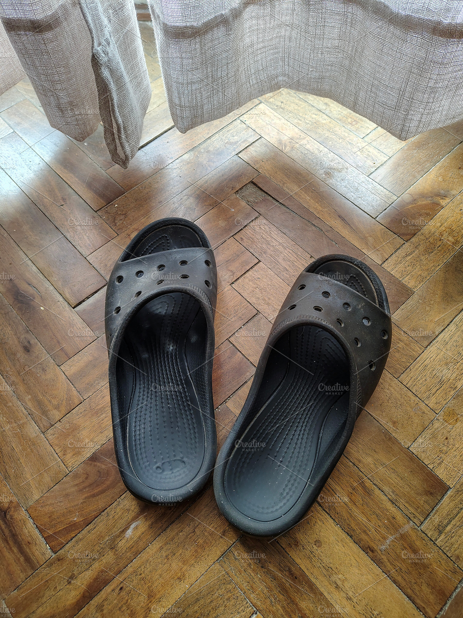 Black worn-out slippers on a wooden parquet floor, a Beauty & Fashion Photo by DanFLCreativo