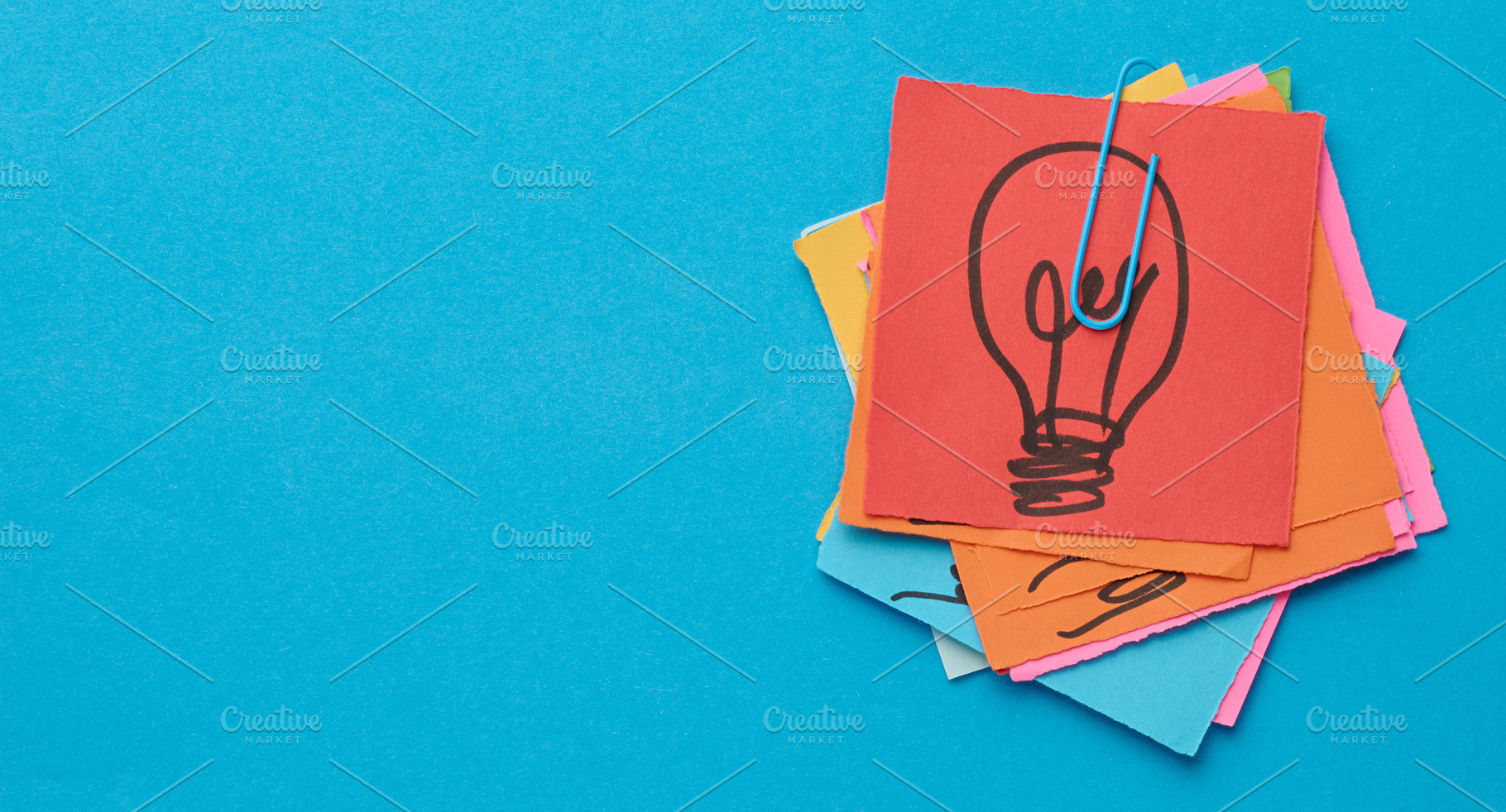 A stack of sticky notes with a light bulb drawn on them is held, a Business Photo by ndanko