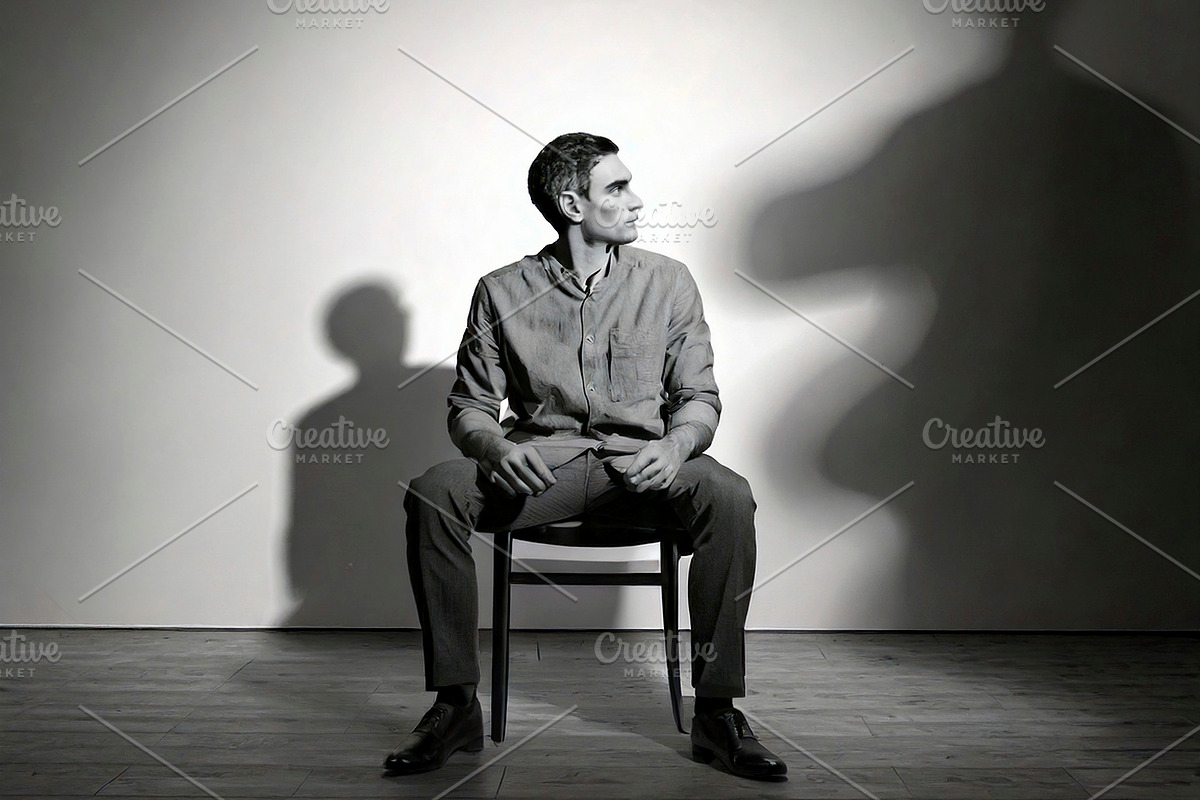 Person sitting alone on a chair with in an empty room at backgro, a Health & Medical Photo by DanFLCreativo (Photo 2 of 2)