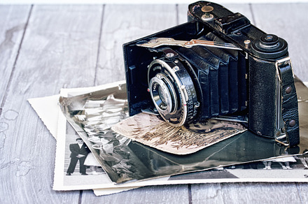 Photo camera on pile of old photos featuring camera, photo, and vintage, an Arts & Entertainment Photo by Neirfy