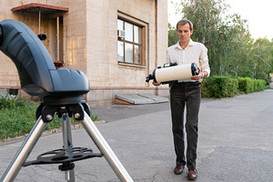 Astronomer carrying telescope tube, a School & Education Photo by Elena Vagengeim
