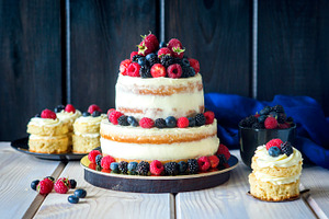 Two tiered white semi naked cake with fresh berries for a wedding or a party