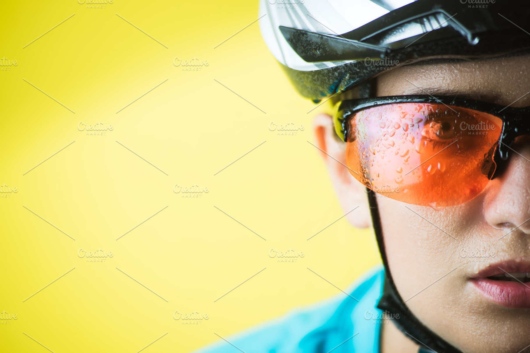 Closeup portrait of female cyclist containing cyclist, helmet, and biker, a Sports & Recreation Photo by BodiaPhoto