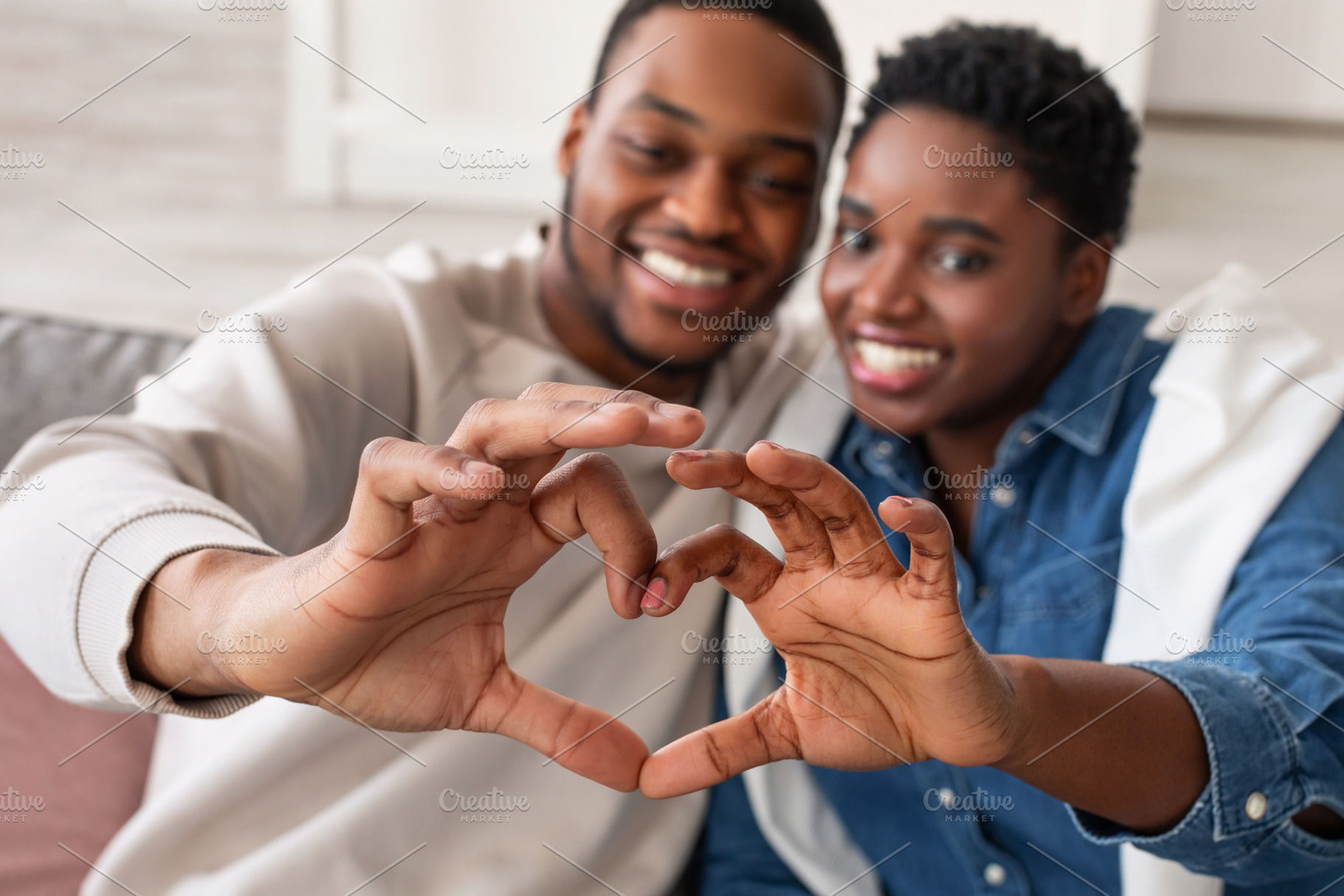 Portrait of african american couple making heart shape with hands, a Photo by Prostock-Studio