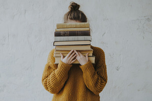 Woman Holding a Stack of Books in Cozy Knit Sweater, an Abstract Photo by Natalia Klenova's Shop