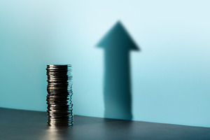 Coins stacked cast a tall upward arrow shadow, reflecting financ, a Photo by salmon.black
