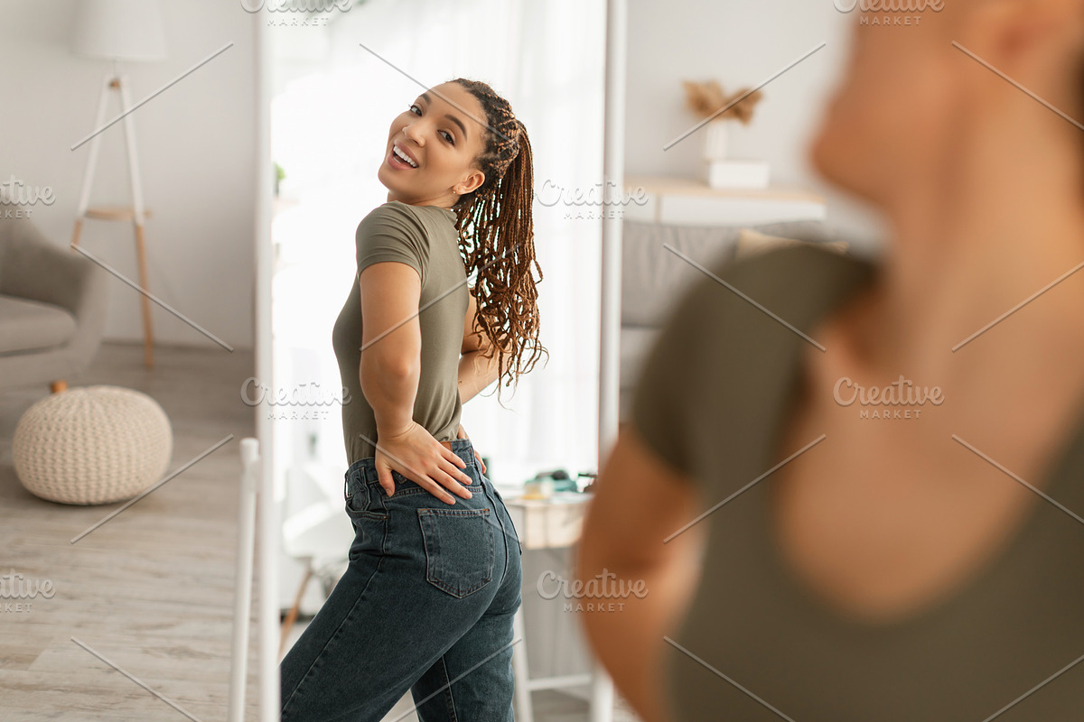 Joyful African Woman Looking At Mirror After Slimming At Home, a Photo by Prostock-Studio (Photo 3 of 3)