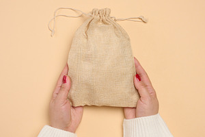 A woman's hands, clad in a white knitted sweater, hold a burlap, a Person Photo by ndanko
