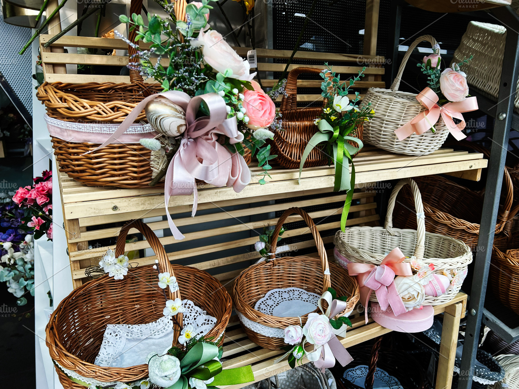 Decorative wicker baskets with floral and ribbon adornments displayed on wooden, a Photo by AS photostudio