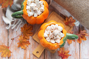 Pumpkin mugs filled with hot chocolate warming up for fall, a Food & Drink Photo by Olena Rudo