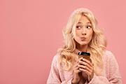 Dreamy young lady holding takeaway coffee and looking aside at empty space on p, a Photo by Prostock-Studio (Thumbnail 1 of 2)