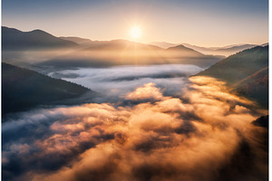 Mountains in low clouds at sunrise, a Nature Photo by den-belitsky