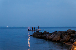 Silhouette of man fishing on lake Garda, a Nature Photo by Bepslabor