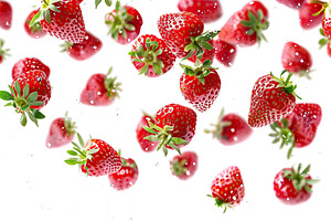 Ripe strawberries flying in the air on white background, a Food & Drink Photo by AlyaAnd