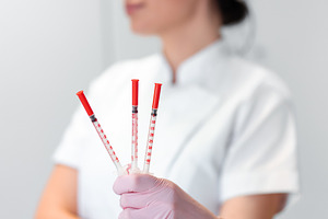 Female cosmetologist holding injection syringes in beauty clinic, a Photo by andreonegin market