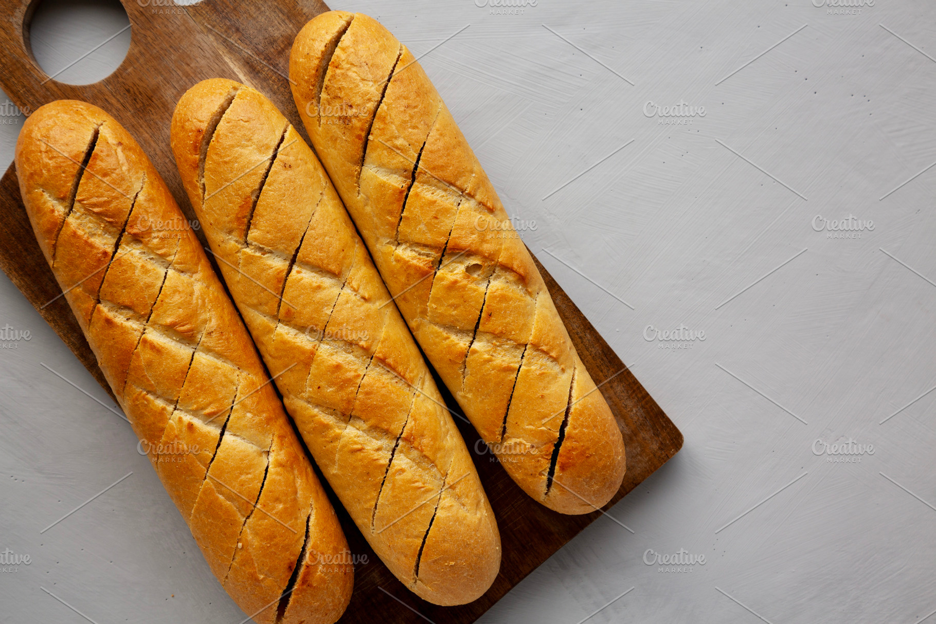 Homemade French Baguette with Garlic Filling on a wooden board,, a Food & Drink Photo by LiudmylaChuhunova
